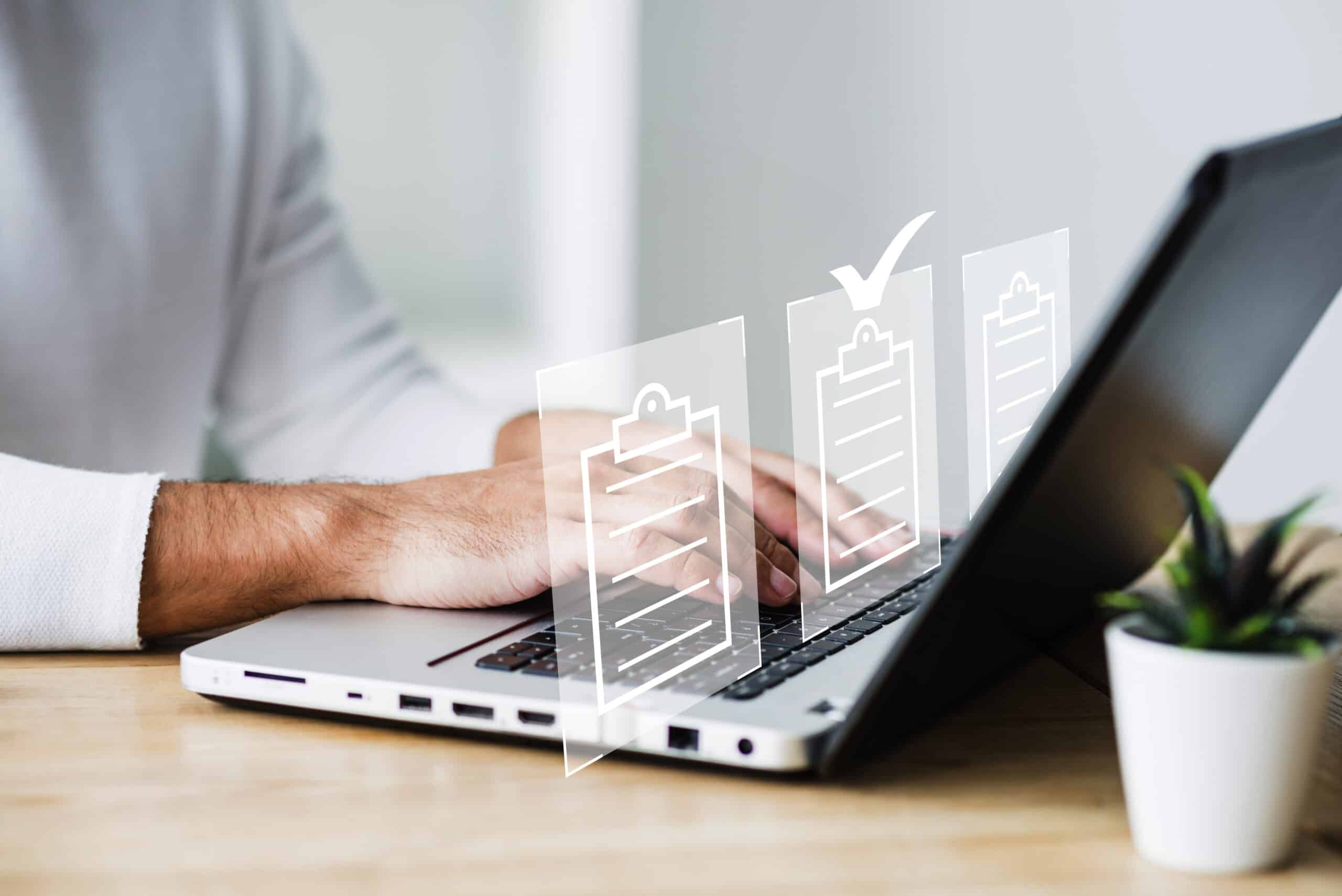 Pessoa digitando em um notebook com &iacute;cones de checklist e documentos digitais sobrepostos