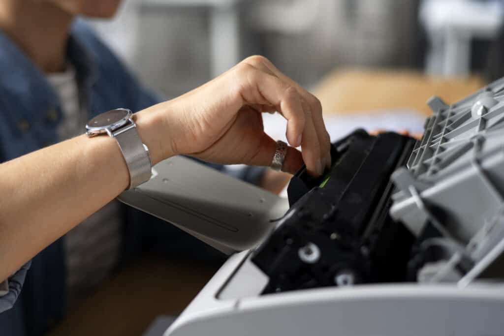 O que fazer com o toner que já foi usado? Descubra! 4 Pessoa trocando o toner no interior de uma impressora