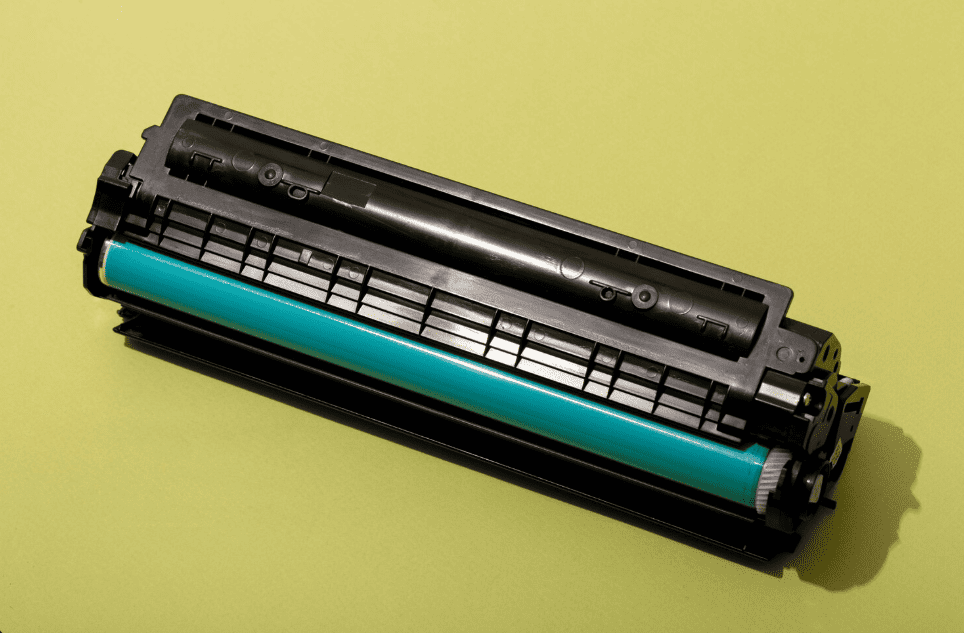 Cartucho de toner de impressora a laser visto de perto sobre fundo amarelo