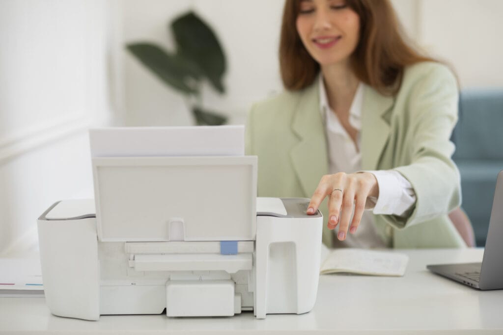 Mulher sorrindo enquanto utiliza uma impressora multifuncional no escritório